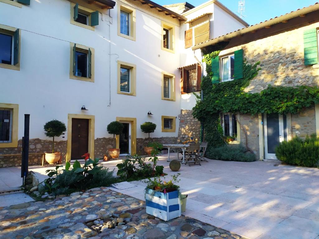 - un grand bâtiment blanc avec une terrasse en face dans l'établissement Ca'Joleo - Relax in Campagna del Lago di Garda, à San Giorgio in Salici