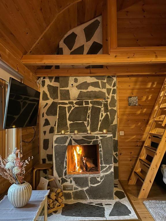a stone fireplace in a living room with a tv at Rukan HonkaLempi in Ruka
