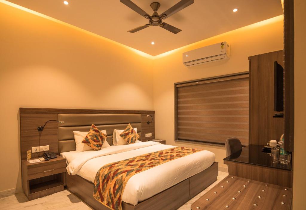 a bedroom with a bed and a ceiling fan at Vashishth Guest House in Rishīkesh