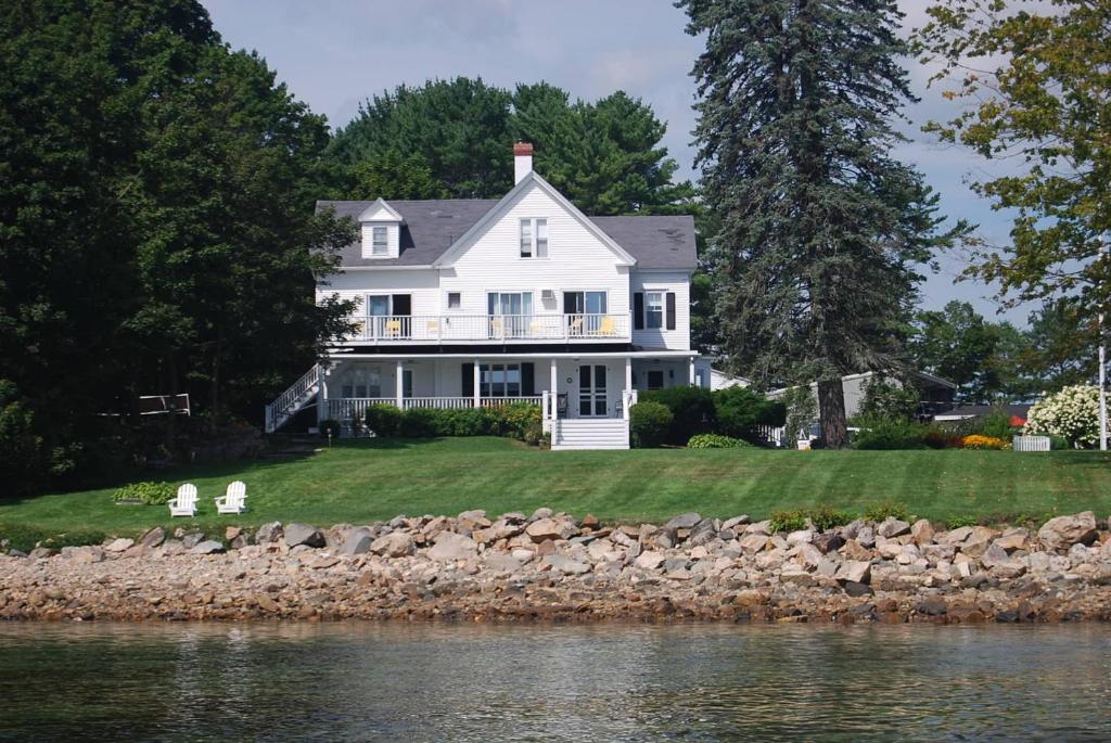 a white house on the shore of a body of water at Dockside Guest Quarters in York