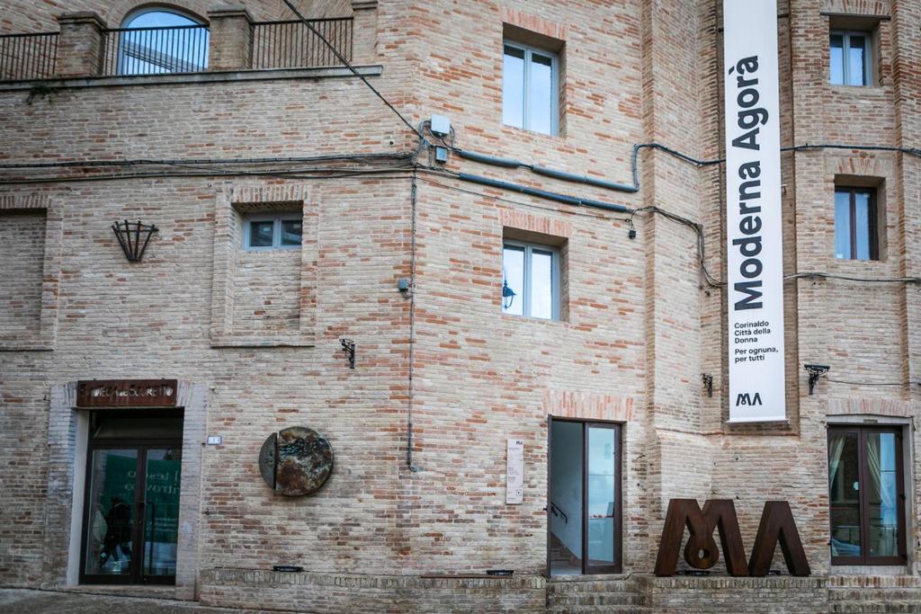 a brick building with a sign on the side of it at MA Hotel in Corinaldo