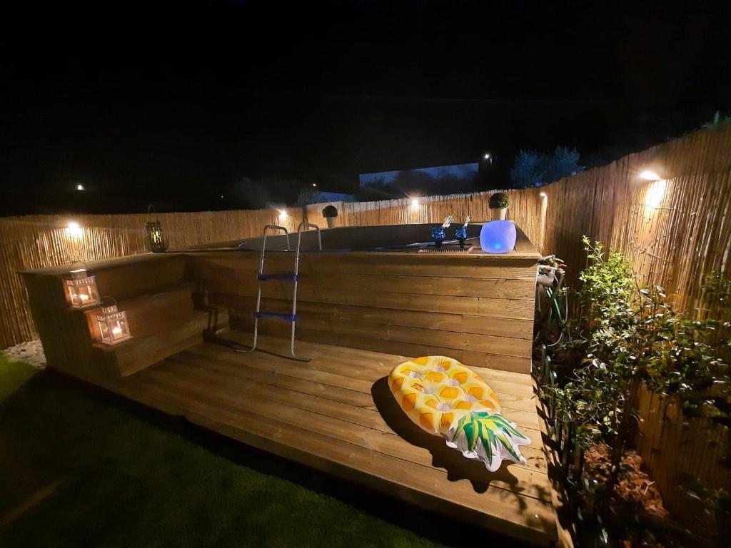 a jacuzzi tub in a backyard at night at A CASA DA VILA in Ermidas