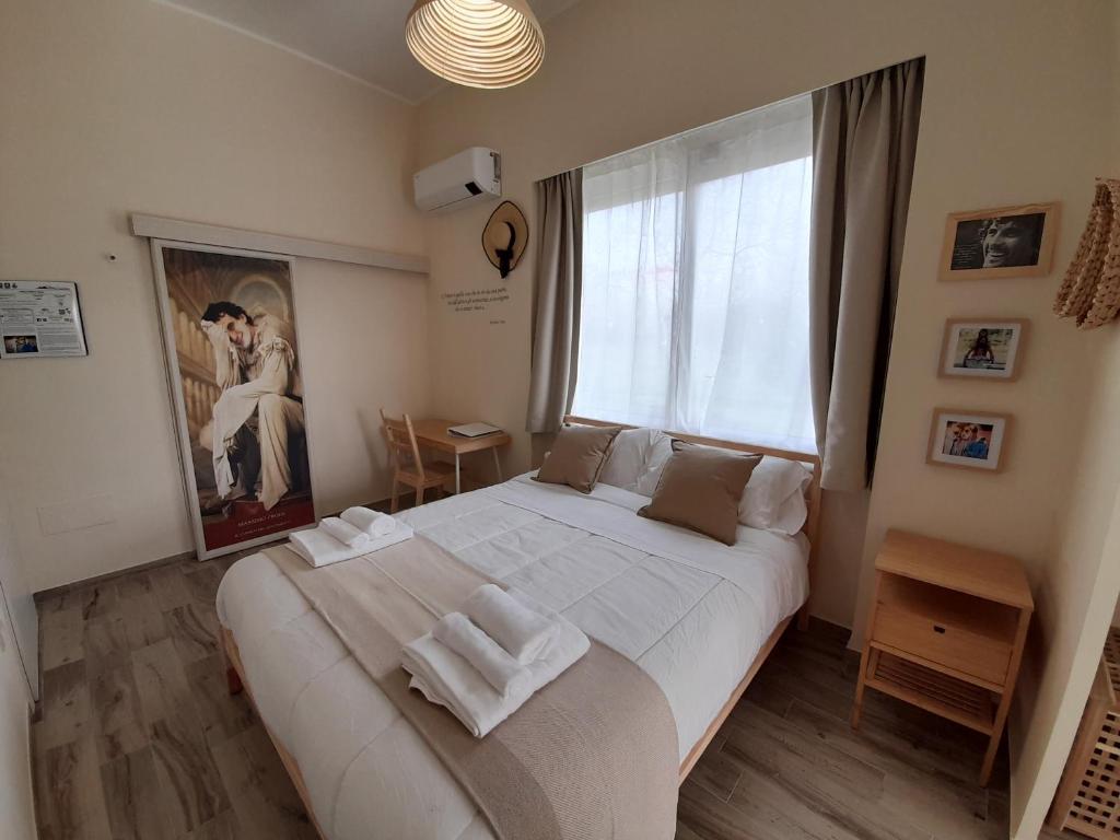 a bedroom with a large white bed and a window at ARCO VESUVIANO in Madonna dellʼArco