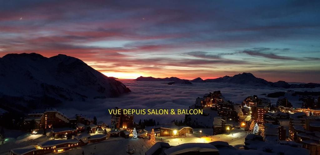 uma vista para uma cidade à noite com as montanhas em F2 résidence Antarès em Avoriaz