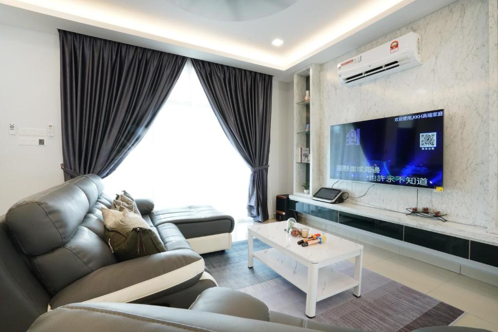 a living room with a couch and a tv at Desaru KTV Classical Elegant Style by Joyfully 2M2 in Desaru