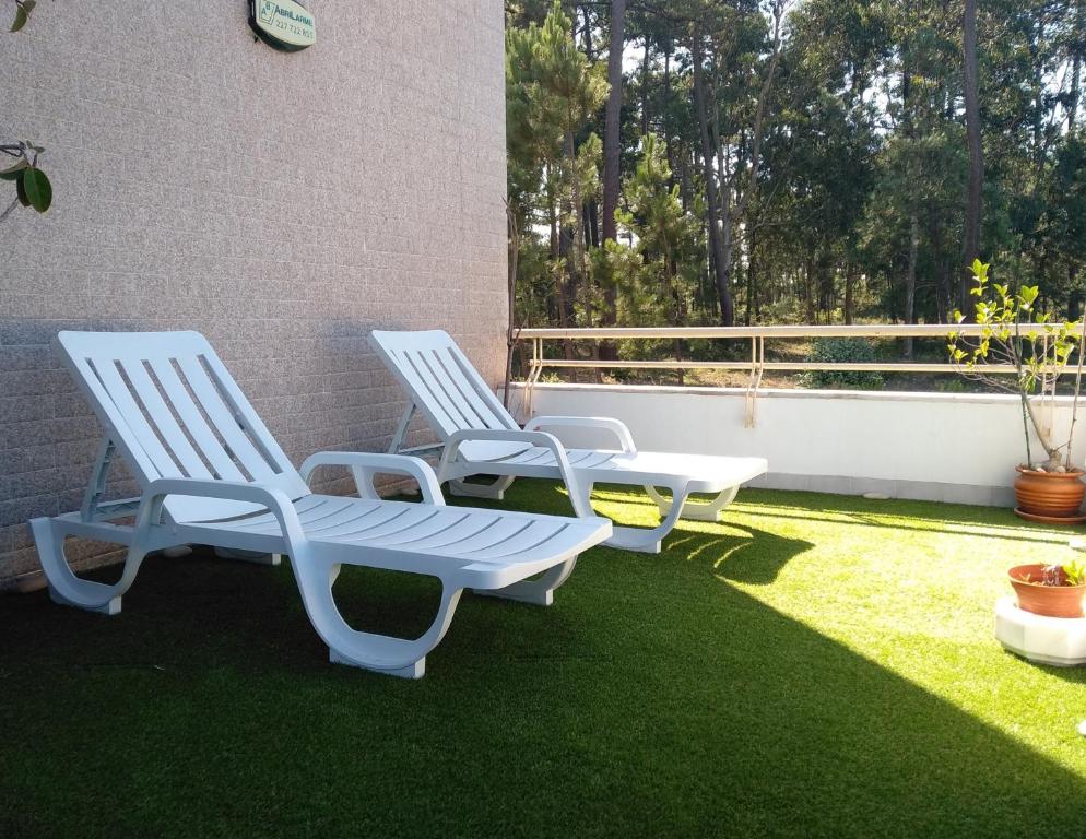 3 chaises et une table sur une terrasse avec pelouse dans l'établissement AZURARA BEACH large and sunny apartment, à Árvore
