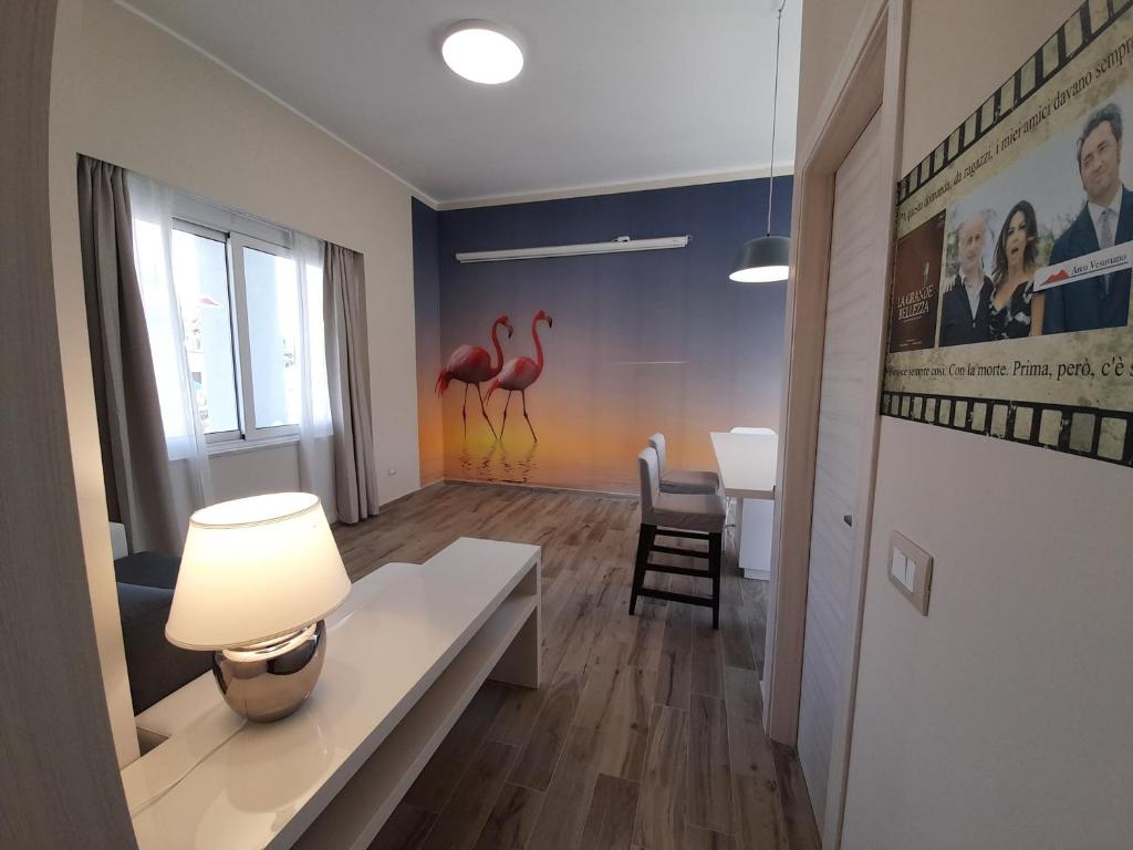 salon ze stołem i różowymi flamingami na ścianie w obiekcie ARCO VESUVIANO w mieście Madonna dellʼArco