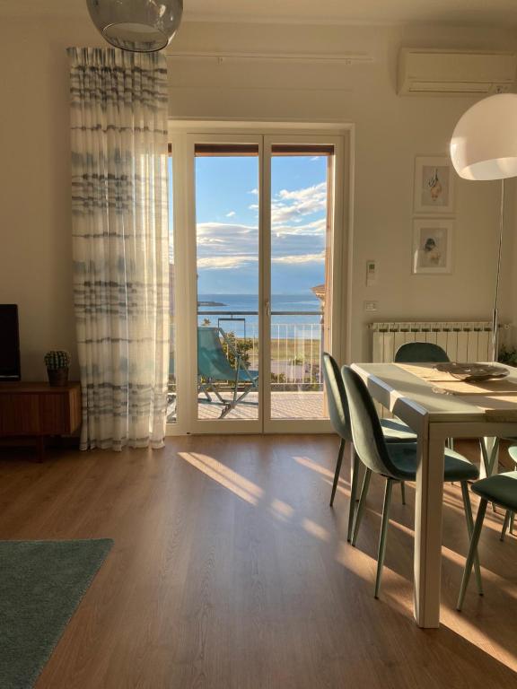 una sala da pranzo con tavolo e vista sull'oceano di Aquamarine Apartment a Castellammare di Stabia