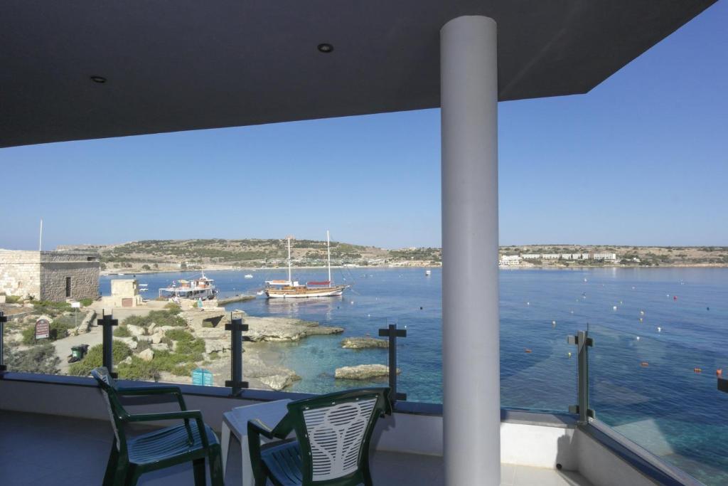 - balcone con vista sull'acqua e su una barca di Mellieha2 Bayfront sea sun & history a Mellieħa
