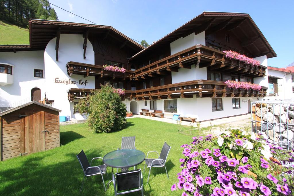 ein Haus mit einem Tisch und Stühlen im Hof in der Unterkunft Gurglerhof in Sölden