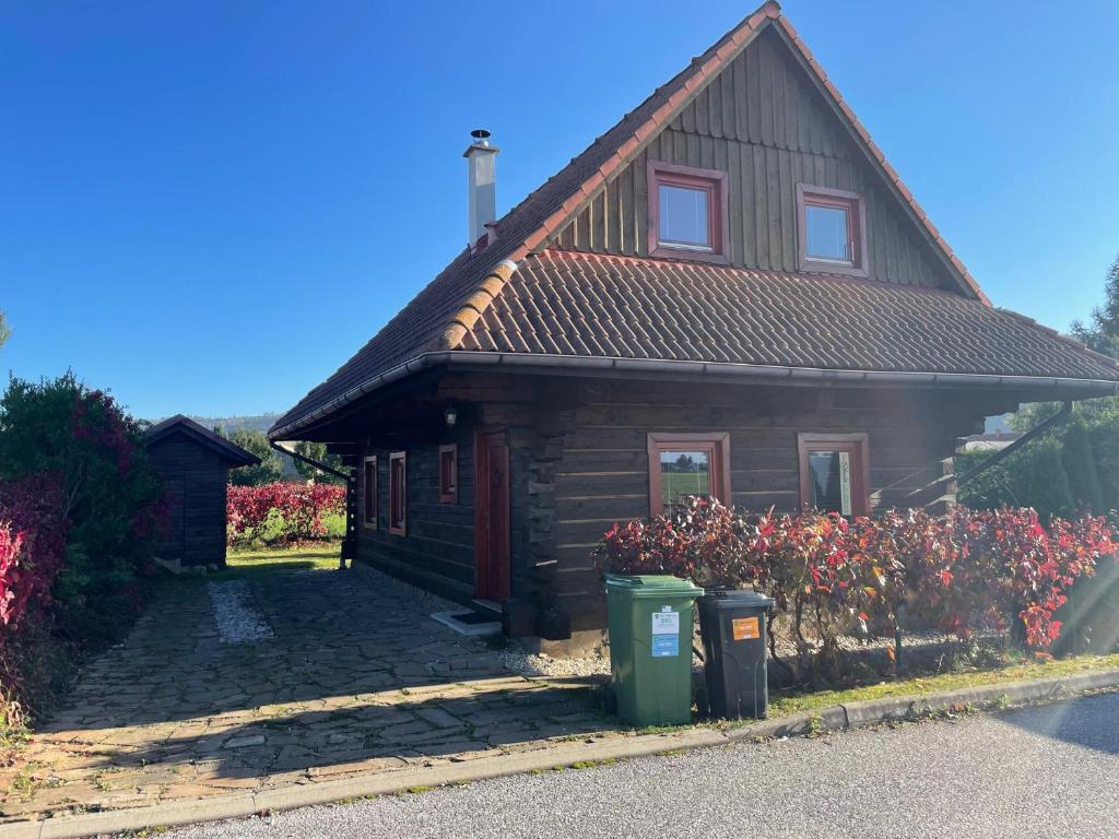 a wooden house with flowers in front of it at Chalupa Pohoda Slovenský raj Hrabušice in Hrabušice