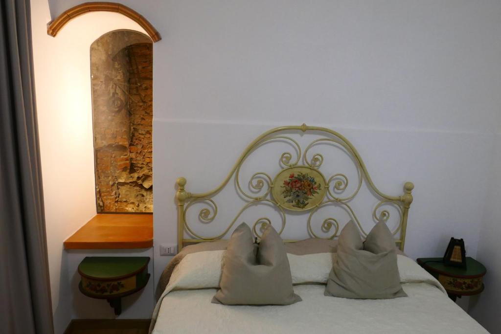 una camera con un letto bianco con due cuscini di Appartamento Antico Pozzo a Prato