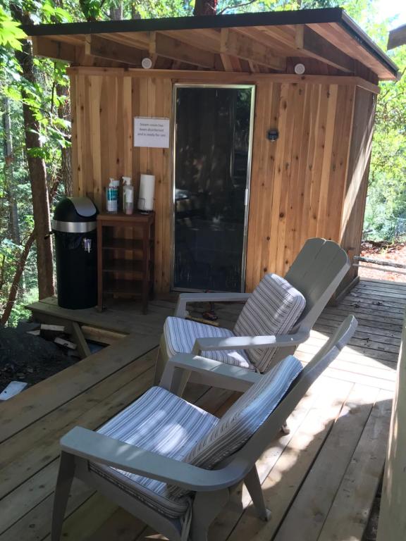 two chairs sitting on the deck of a cabin at Five Elements Lodge B&B with Outdoor Spa in Fernwood