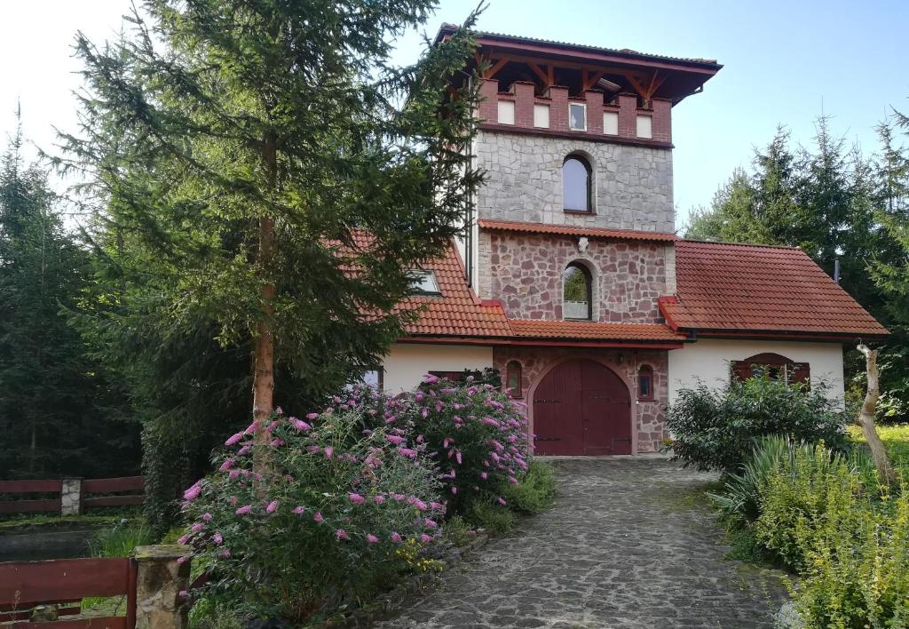 ein Gebäude mit einem Uhrturm darüber in der Unterkunft Wieża Na Górce in Kunów