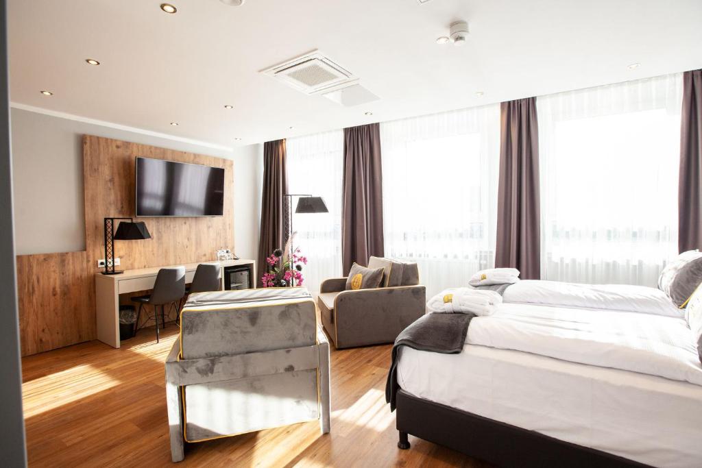 a bedroom with two beds and a desk with a computer at Elens Hotel in Bremen