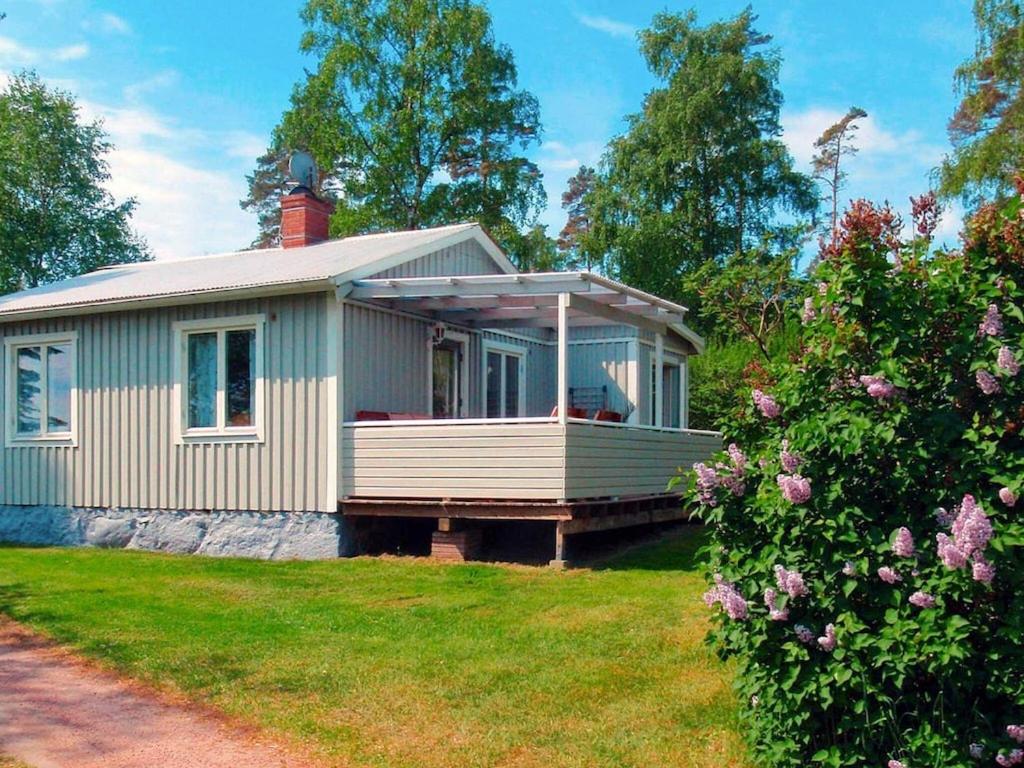 una pequeña casa con porche en el césped en 4 person holiday home in KRISTIANSTAD en Kristianstad