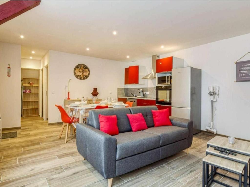 een woonkamer met een grijze bank en rode kussens bij Ceriflor-Le Vignemale in Cauterets