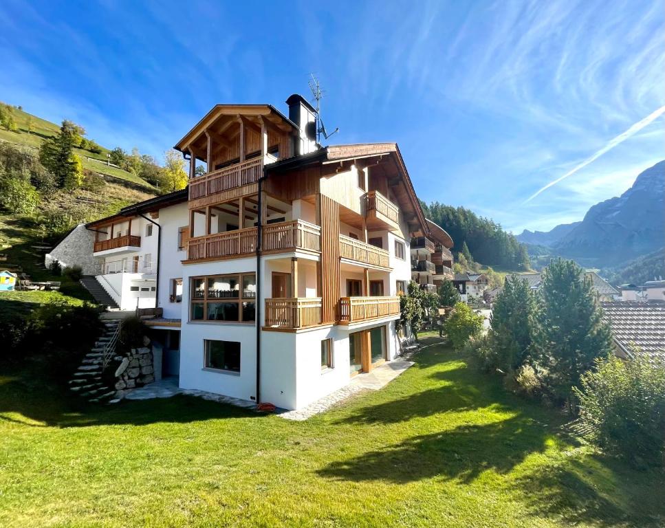 una casa en las montañas con césped verde en Ciasa de Zeno, en La Valle