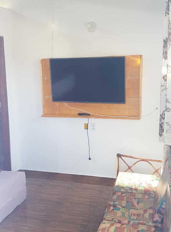 a flat screen tv hanging on a wall at Casa do Angelo in Ilha de Boipeba