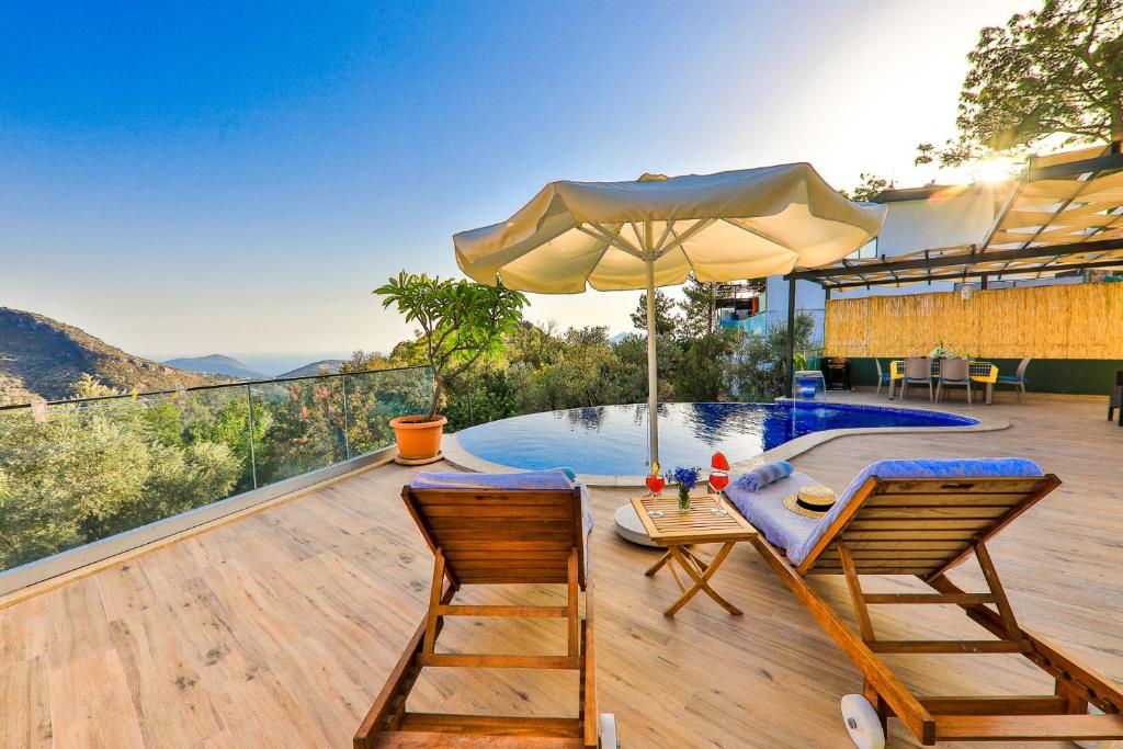 a patio with a table and two chairs and an umbrella at Villa Fiore in Kalkan