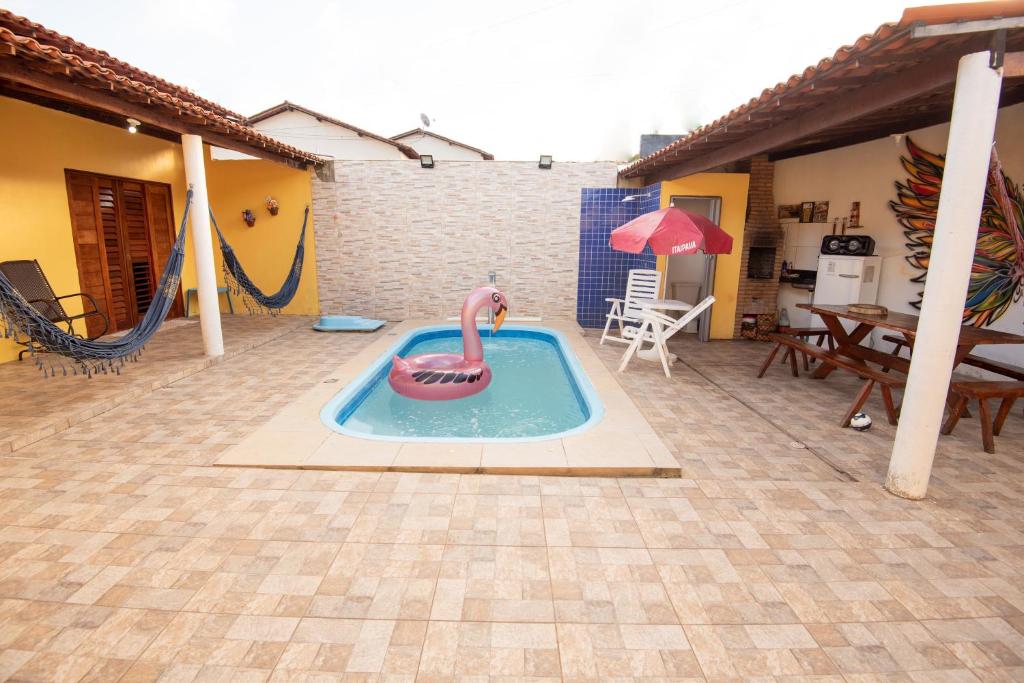 聖米格爾－杜斯米拉格里斯的住宿－Toca do hamster - MILAGRES，后院的游泳池,带有粉红色的火烈鸟