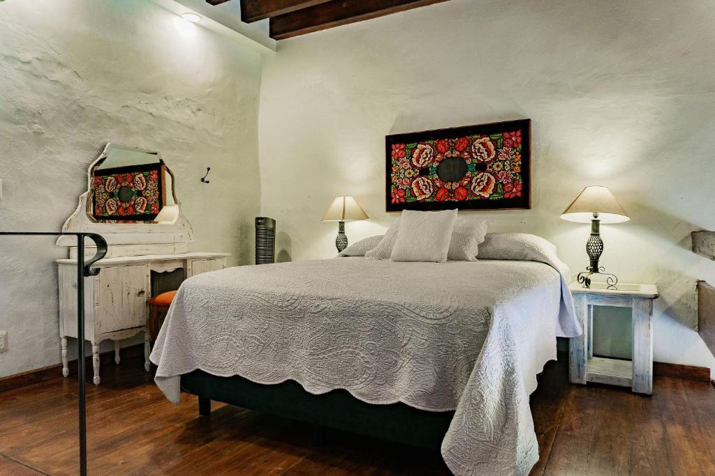 a bedroom with a bed with a painting on the wall at Hotel Casa Pereyra in Oaxaca City
