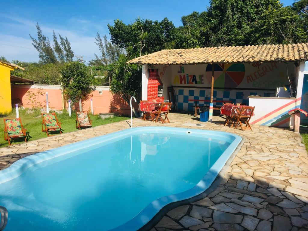 una piscina azul en un patio con sillas en Sítio da amizade casa piscina churrasqueira, en Búzios