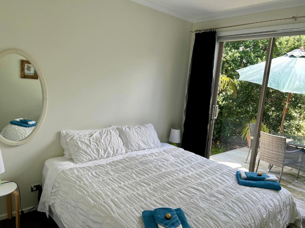 a bedroom with a bed with blue towels on it at Jennie's In Whitianga in Whitianga