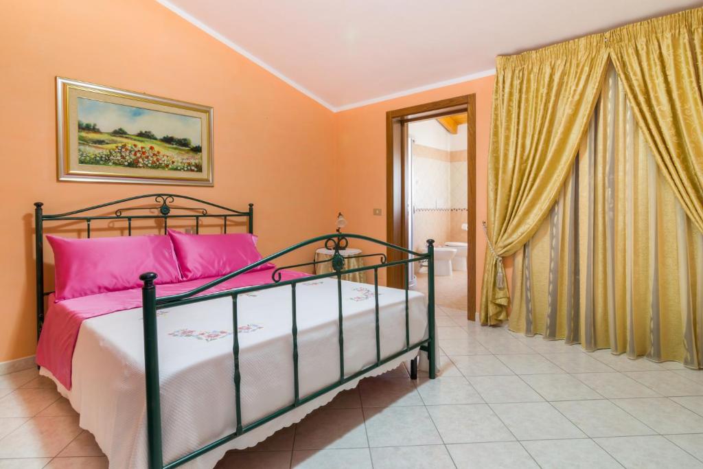 1 dormitorio con 1 cama con almohadas rosas en Casa Titti en Càbras