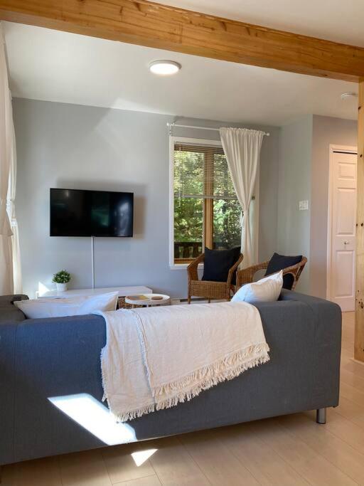 ein Schlafzimmer mit einem großen Bett und einem Sofa in der Unterkunft Chalet «L'Autrichien» de Charlevoix in Petite-Rivière-Saint-François
