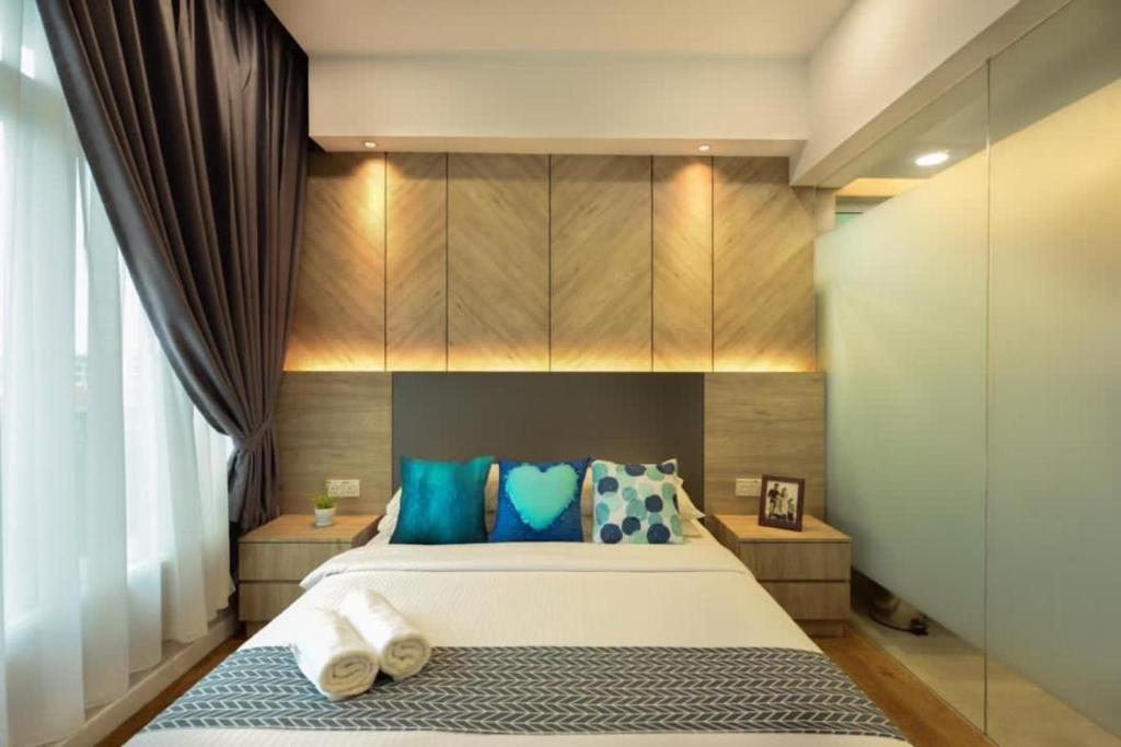 1 dormitorio con 1 cama grande con almohadas azules en Designer Suite Apartment Seaview 10pax Families Suite en Kuah