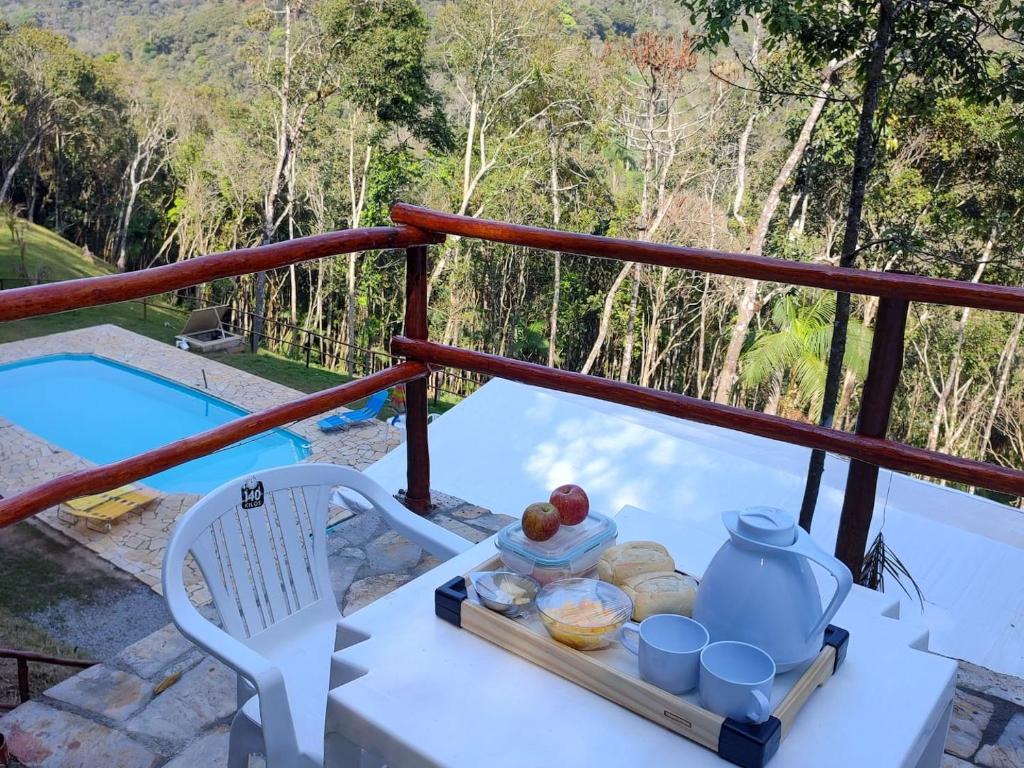 ein Tablett mit Speisen auf einem Tisch auf einem Balkon in der Unterkunft Jângala Glamping Natureza in Juquitiba