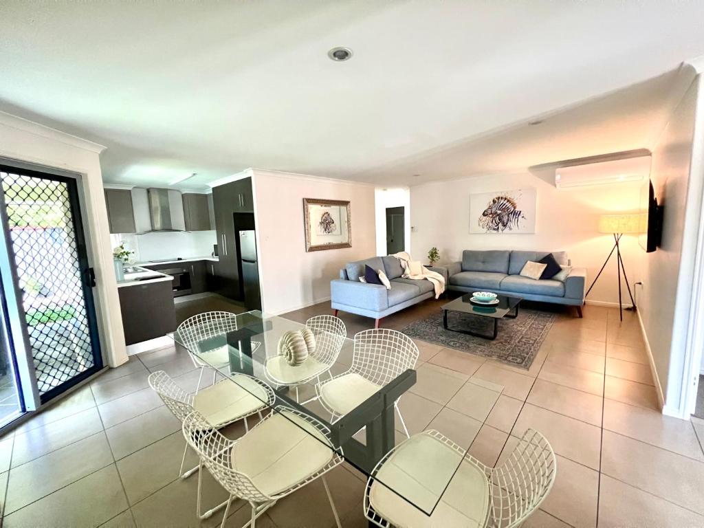 uma sala de estar com mesa e cadeiras em Bundys Best! Modern Luxury in the heart of town em Bundaberg