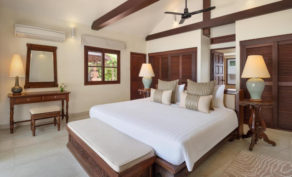 a bedroom with a large white bed and a mirror at Ban Haad Sai - Beachfront Private Villa in Bangrak Beach