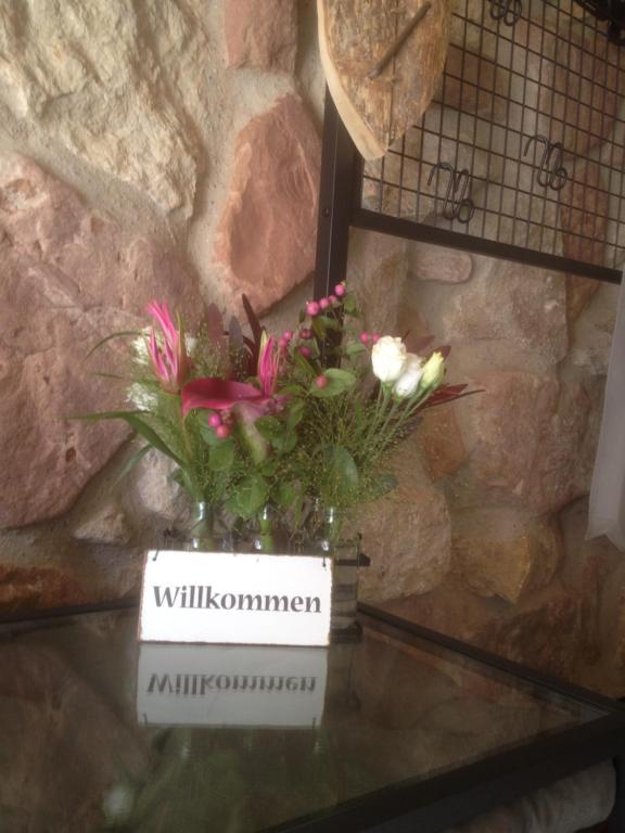 un jarrón de flores sentado en una mesa en Heiderose` s en Naumburg (Saale)