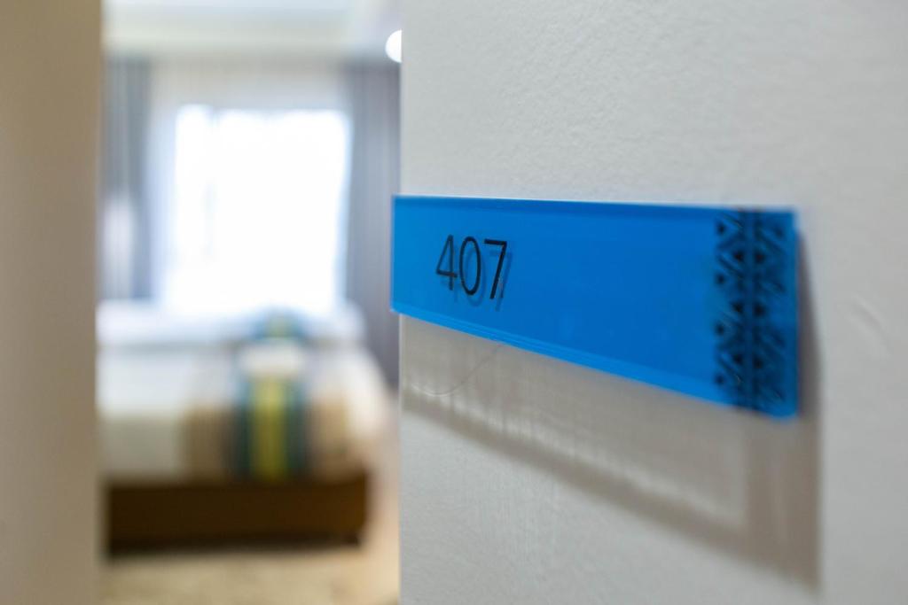 a blue sign on a wall next to a room at Kozi Suites Nairobi Airport in Nairobi