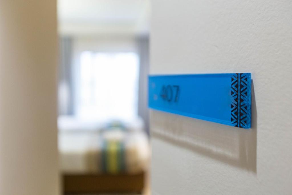 a blue clock on a wall in a room at Kozi Suites Nairobi Airport in Nairobi
