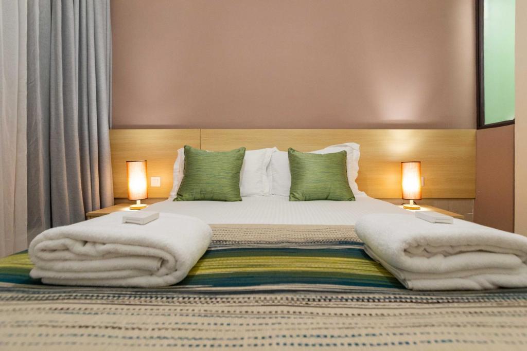 a bedroom with a large bed with two lamps at Kozi Suites Nairobi Airport in Nairobi