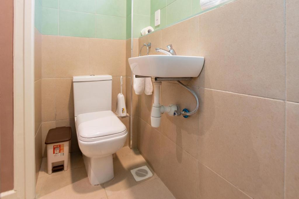 a bathroom with a toilet and a sink at Kozi Suites Nairobi Airport in Nairobi