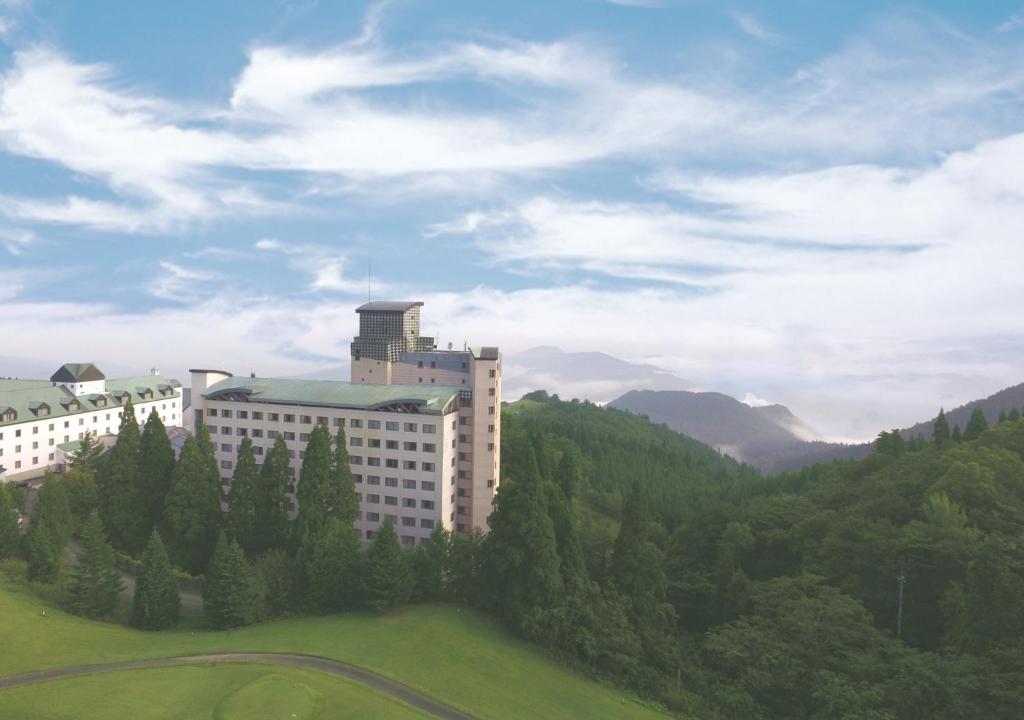 ein Gebäude auf einem Hügel mit Bäumen in der Unterkunft Aomori Winery Hotel in Ōwani