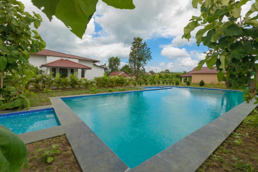 a swimming pool in front of a house at TULI VEER BAGH RESORT TURIA in Khawāsa