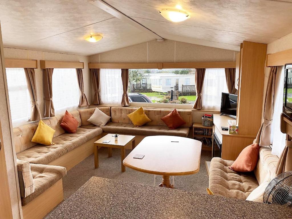 a living room with a couch and a table at Devon Barnstaple Self Catering Accommodation Tarka Holiday Park, A14 Free Wi-Fi Spacious Tarka Holiday Park sleeps 5 Pets allowed Static Caravan home Devon EX31 4AU just 6 miles from Saunton Sands in Barnstaple