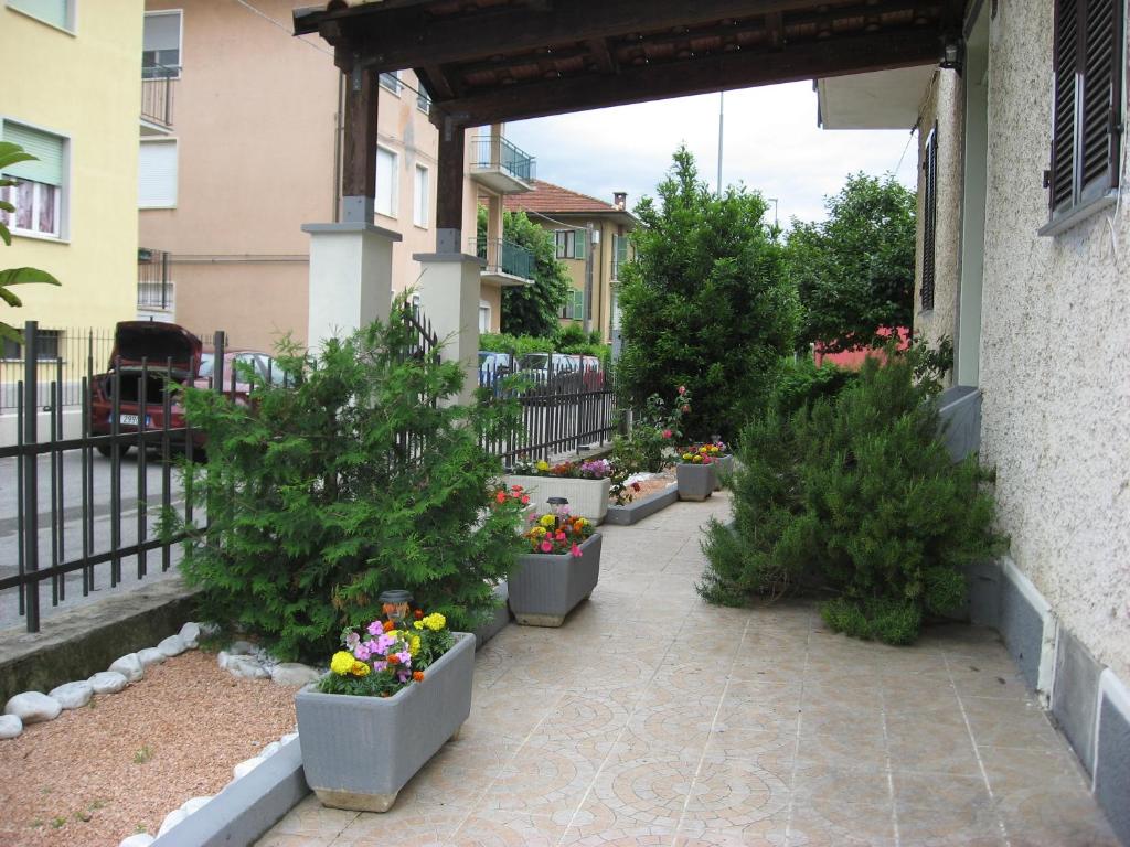 a courtyard with trees and flowers in pots at Casa Bruno B&B in Mondovì