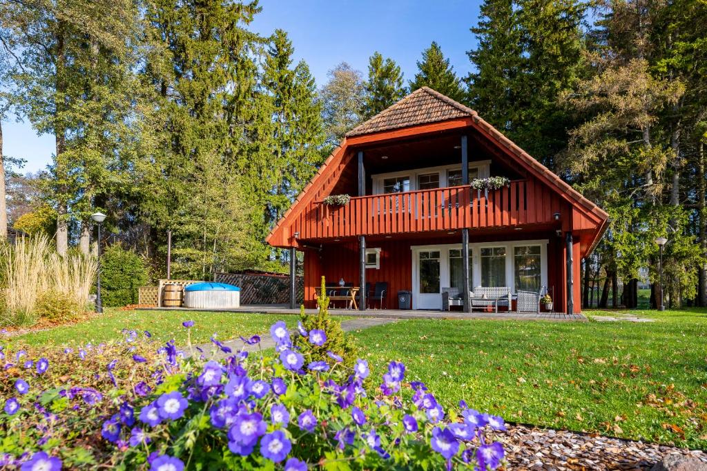 una pequeña casa con flores púrpuras delante de ella en Nuutri Villa, en Kärdla