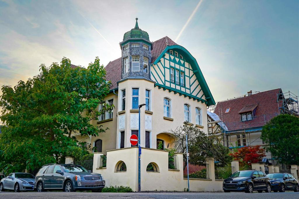 duży budynek z samochodami zaparkowanymi przed nim w obiekcie Traumhaft wohnen in Jugendstilvilla w mieście Spira