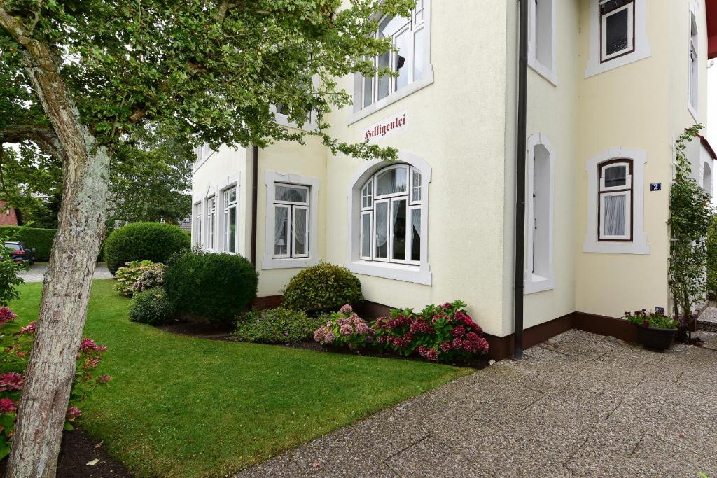 un edificio blanco con flores en el patio delantero en Pension Hilligenlei Zi 04 DZ, en Wyk auf Föhr