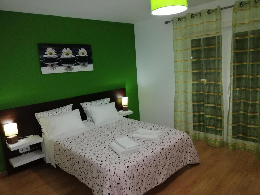 Dormitorio verde con cama y pared verde en Casa do Adro - Serra da Estrela, en Cortes do Meio