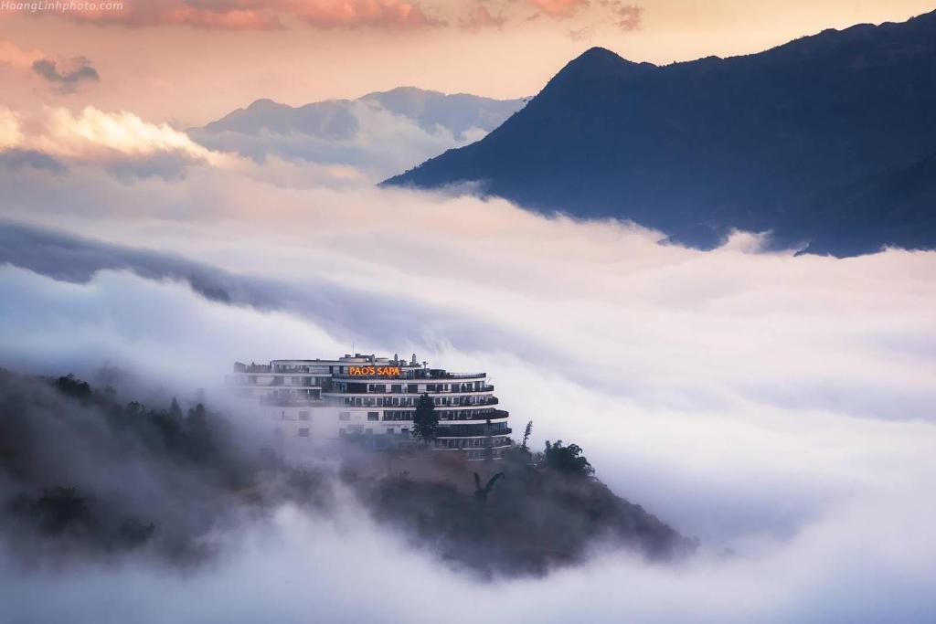 a building on top of a mountain above the clouds at Pao's Sapa Leisure Hotel in Sa Pa