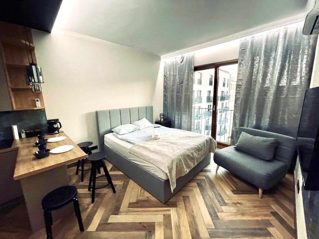 a bedroom with a bed and a desk and a chair at Icon Apartaments Drobnera studio in Wrocław