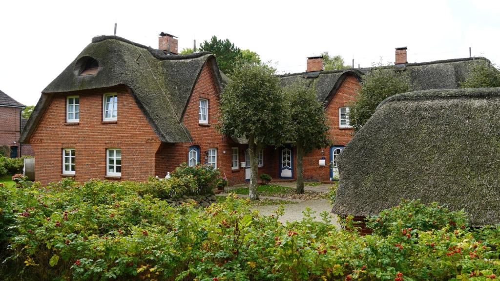 an old brick house with a thatched roof at Haus Bornholm Whg 23 in Nieblum